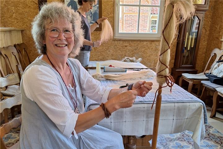Anja Roerdink zeigt wie man Flachsfasern auf Spinnrocken wickelt und dann spinnt. Fotos: Karin Printing