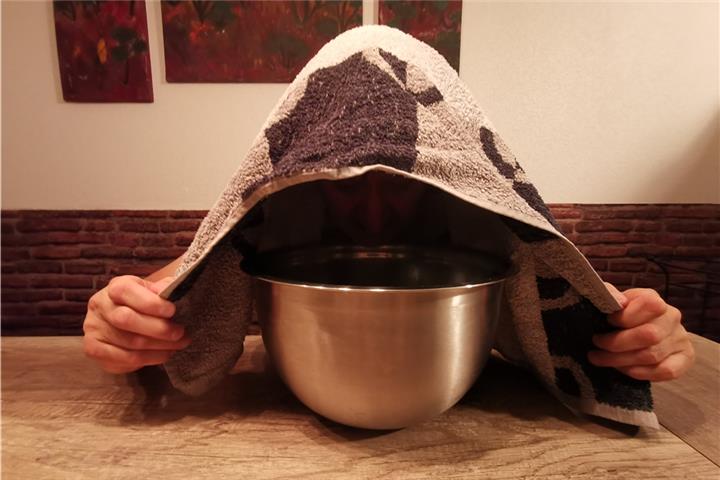 Nicht nur gut gegen Pickel: Ein Dampfbad mit Kamillenblüten. Heißes Wasser mit den Blüten vermischen, kurz ziehen lassen. Den Kopf über dem Topf mit dem Handtuch bedecken, sodass der Dampf nicht entweichen kann. 8 bis 10 Minuten durch Nase und Mund atmen. Danach Gesicht waschen. Foto: mtg