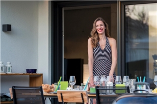 Teller, Besteck oder die Schüssel Salat für den Grillabend eben schnell durchs Fenster reichen? Kein Problem mit einem Dreh- oder Pendelfenster als Insektenschutz. Foto: HLC/Neher